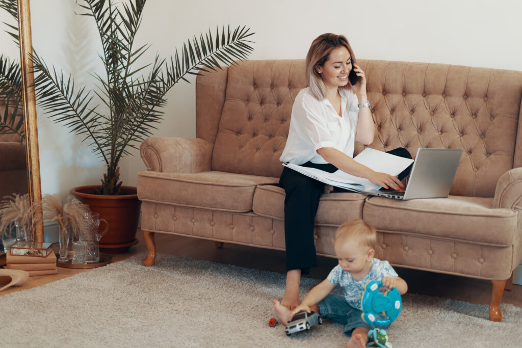 Beautiful business woman working at home. Multi-tasking, freelance and motherhood concept. Working mother career